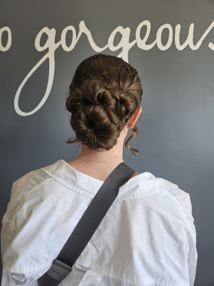 A woman after Addi gave her a low bun updo.