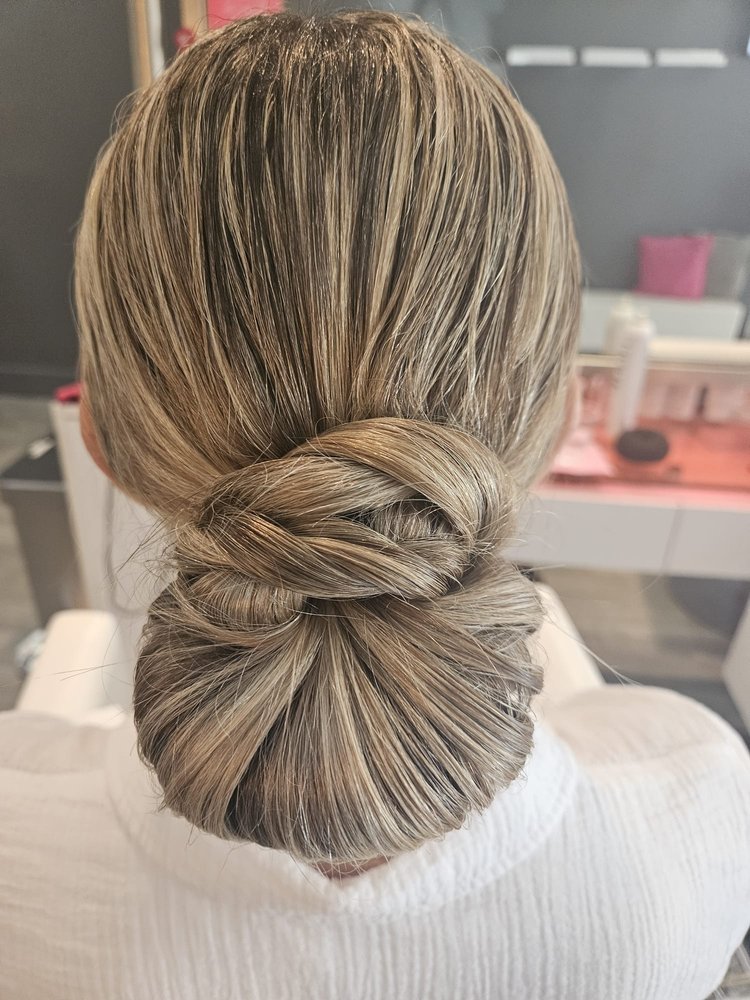 Close up of a woman after Addi gave her a low bun updo.